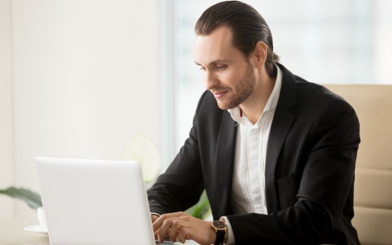 A imagem mostra um homem em roupas sociais utilizando o computador. Ela busca representar como funciona o executive search.