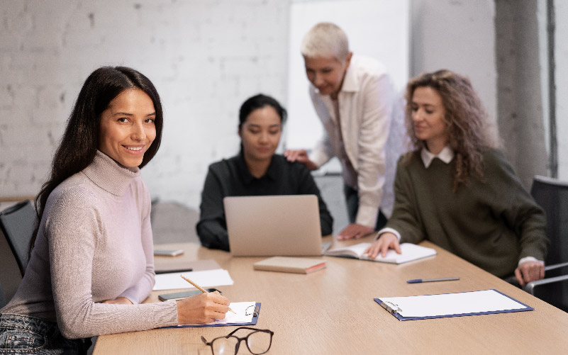 Quatro funcionários em uma mesa de escritório discutindo o que é EVP e como impacta na empresa onde trabalham.