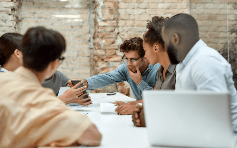 Imagem de capa para artigo sobre high performers, mostrando uma equipe reunida em um ambiente corporativo, colaborando na análise de informações, representando alto desempenho, inovação e trabalho em equipe.