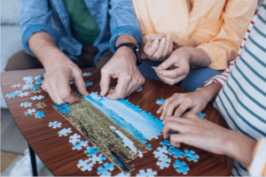 Jogo de quebra-cabeça sendo montado. A imagem busca retratar, de forma lúdica, a dinâmica “corrida do quebra-cabeça”, que pode ser aplicada no team building.