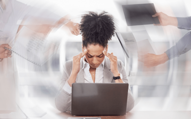 Imagem de capa para artigo sobre síndrome de burnout, com uma profissional sobrecarregada diante de um notebook, simbolizando estresse ocupacional, excesso de demandas e esgotamento profissional.