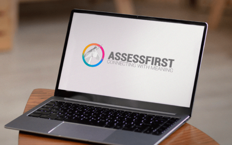 Notebook aberto exibindo a plataforma AssessFirst, ferramenta de assessment para recrutamento e gestão de talentos.